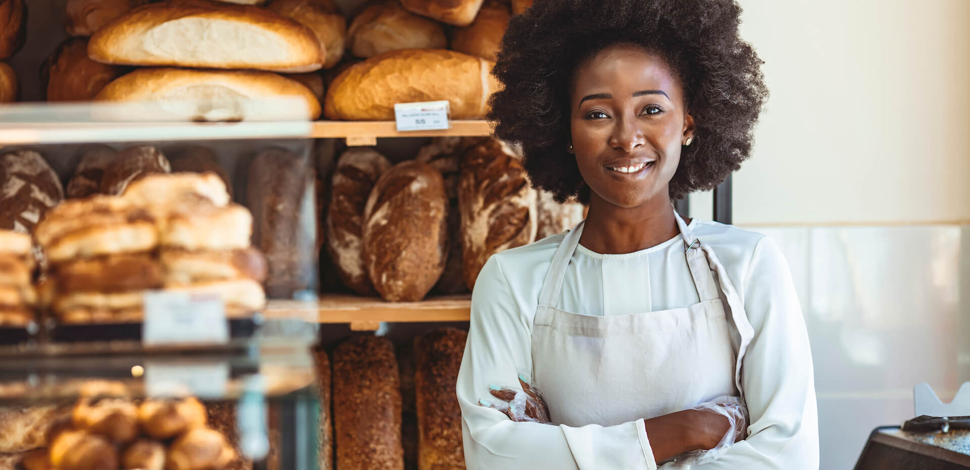Confident African American baker posing in her bakery showing confidence in vision after laser eye surgery.