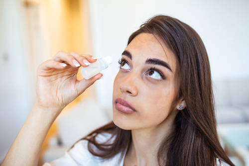 Woman applying eye drops