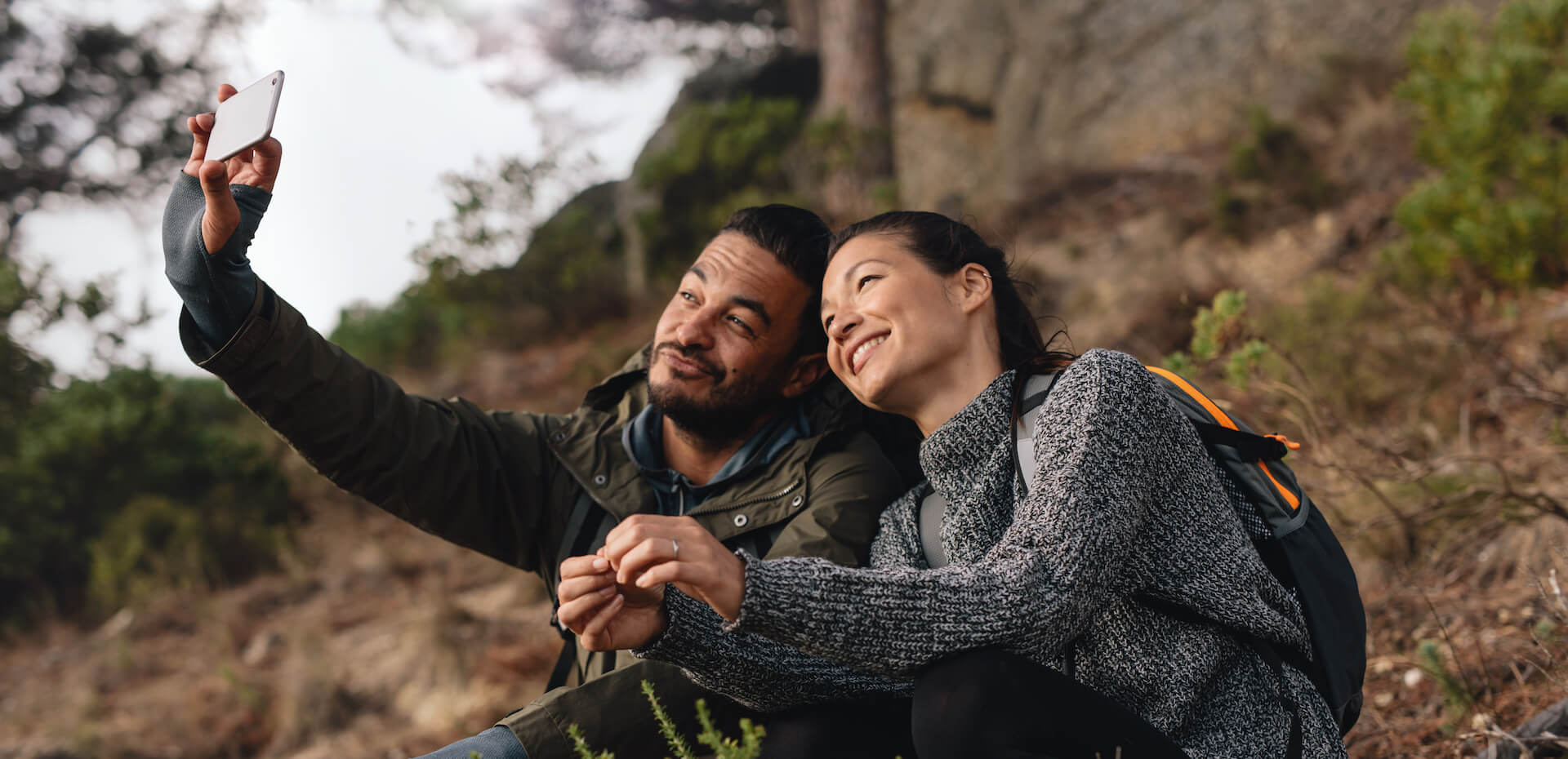 Young couple taking a selfie on a hike. Highlights freedom from glasses and contact lenses with LASIK when outdoors.